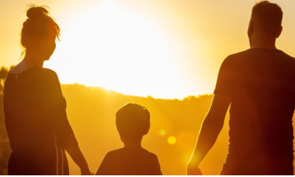 Hogar emocionalmente saludable donde la mama y papa sostienen la mano del niño y ven el atardecer juntos