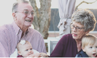 Dos abuelos compartiendo con sus nietos, el articulo destaca la importancia emocional del adulto mayor en las familias